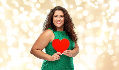 Image showing happy woman holding red heart over lights