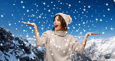 Image showing young woman in winter hat holding something