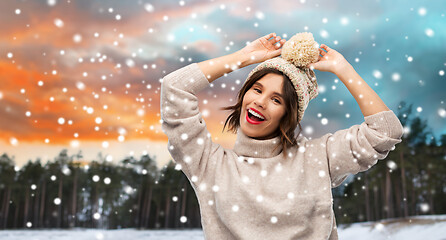 Image showing woman in hat and sweater over winter forest