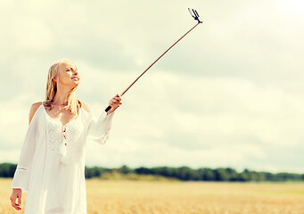 Image showing happy young woman taking selfie by smartphone