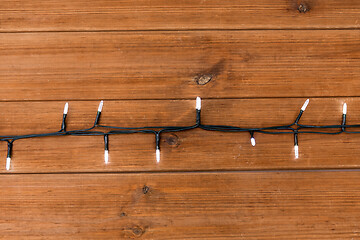 Image showing christmas garland lights on wooden background