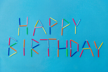 Image showing words happy birthday made of candles on blue