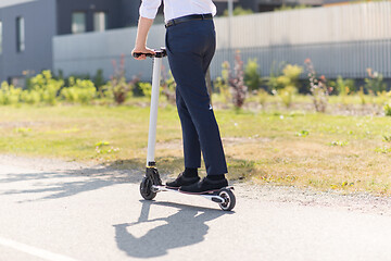 Image showing young businessman riding electric scooter outdoors