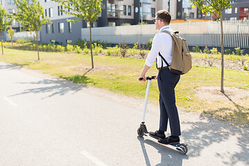 Image showing businessman with backpack riding electric scooter