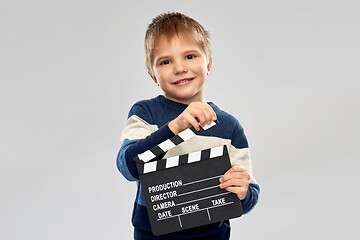 Image showing happy little boy with clapperboard in studio