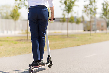 Image showing young businessman riding electric scooter outdoors