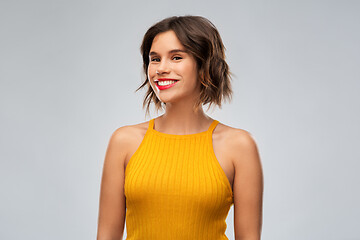 Image showing happy smiling young woman in mustard yellow top