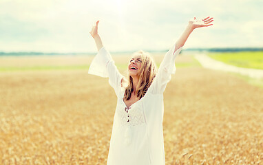 Image showing smiling young woman in white dress on cereal field