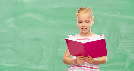 Image showing smiling little girl reading book at school