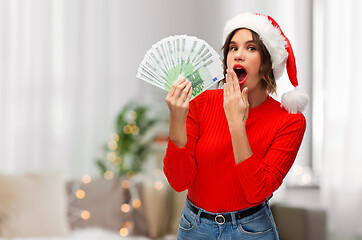 Image showing woman in santa hat with money on christmas