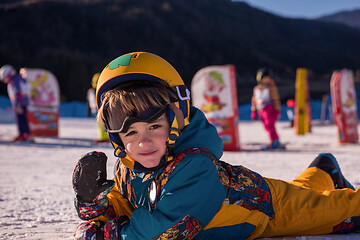 Image showing little snowboarder lying on the snow