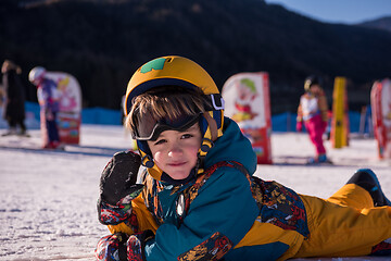 Image showing little snowboarder lying on the snow