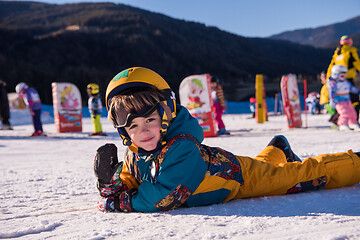 Image showing little snowboarder lying on the snow