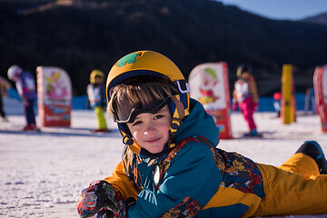 Image showing little snowboarder lying on the snow