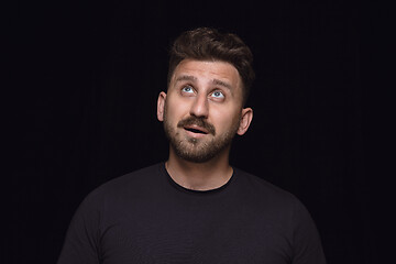 Image showing Close up portrait of young man isolated on black studio background