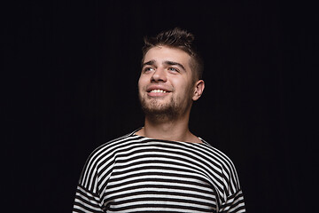 Image showing Close up portrait of young man isolated on black studio background