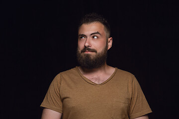 Image showing Close up portrait of young man isolated on black studio background