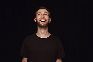 Image showing Close up portrait of young man isolated on black studio background