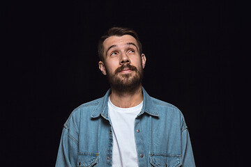 Image showing Close up portrait of young man isolated on black studio background