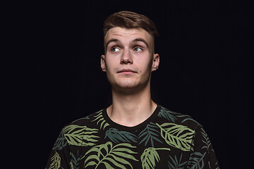 Image showing Close up portrait of young man isolated on black studio background