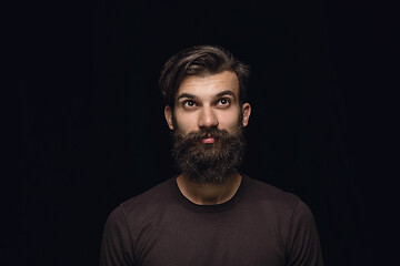 Image showing Close up portrait of young man isolated on black studio background