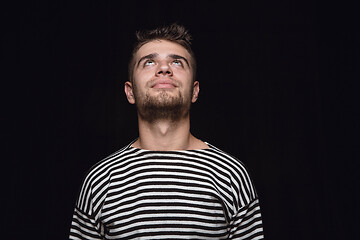 Image showing Close up portrait of young man isolated on black studio background