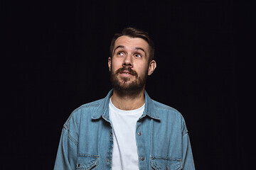 Image showing Close up portrait of young man isolated on black studio background