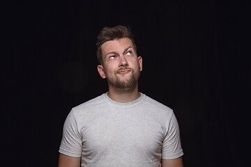 Image showing Close up portrait of young man isolated on black studio background