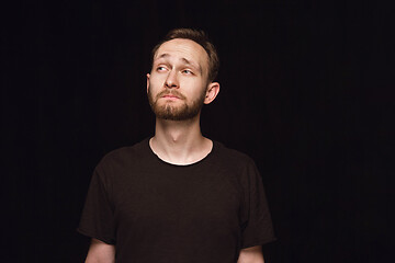 Image showing Close up portrait of young man isolated on black studio background