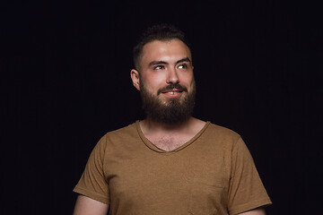 Image showing Close up portrait of young man isolated on black studio background