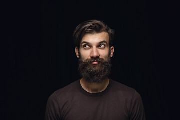 Image showing Close up portrait of young man isolated on black studio background