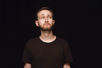 Image showing Close up portrait of young man isolated on black studio background