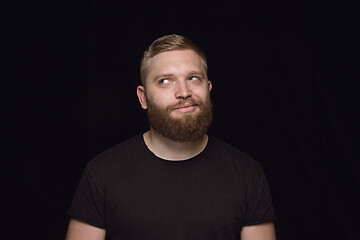 Image showing Close up portrait of young man isolated on black studio background