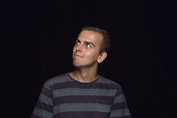 Image showing Close up portrait of young man isolated on black studio background