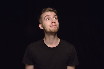 Image showing Close up portrait of young man isolated on black studio background