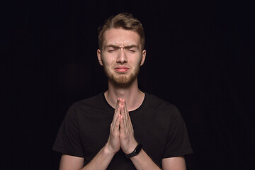 Image showing Close up portrait of young man isolated on black studio background