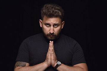 Image showing Close up portrait of young man isolated on black studio background