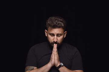 Image showing Close up portrait of young man isolated on black studio background