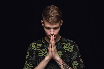 Image showing Close up portrait of young man isolated on black studio background