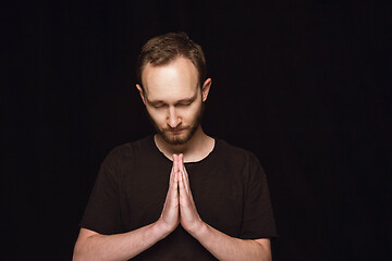 Image showing Close up portrait of young man isolated on black studio background