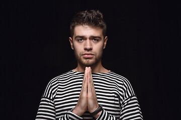 Image showing Close up portrait of young man isolated on black studio background