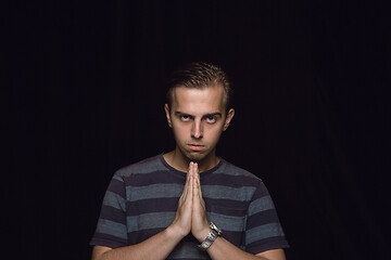 Image showing Close up portrait of young man isolated on black studio background