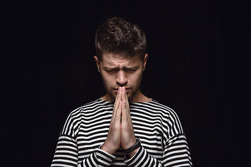 Image showing Close up portrait of young man isolated on black studio background