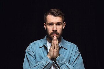 Image showing Close up portrait of young man isolated on black studio background