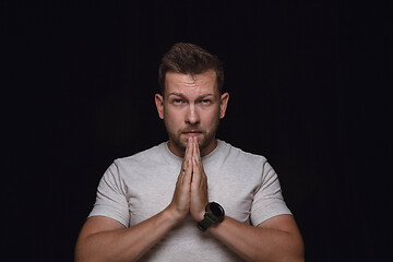 Image showing Close up portrait of young man isolated on black studio background