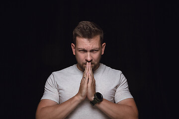 Image showing Close up portrait of young man isolated on black studio background