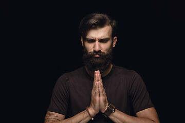 Image showing Close up portrait of young man isolated on black studio background