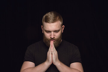 Image showing Close up portrait of young man isolated on black studio background