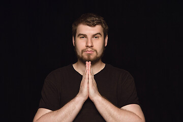 Image showing Close up portrait of young man isolated on black studio background