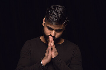 Image showing Close up portrait of young man isolated on black studio background